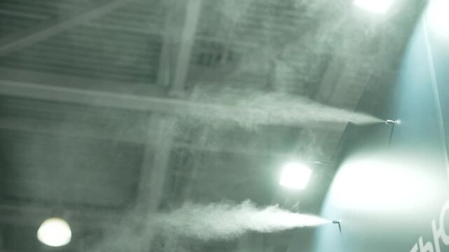 Industrial humidifiers spraying fine mist into the air for air conditioning, cooling, and humidity control in a facility
