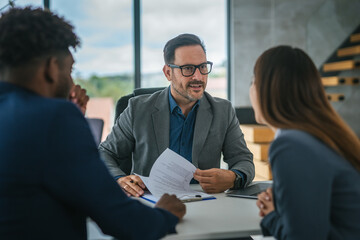 Financial adviser discussing contract with diverse couple in office meeting