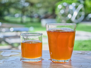 Wild honey in bottles and clear glasses on a wet wooden background