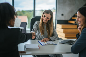 Businesswomen shaking hands after successful job interview meeting