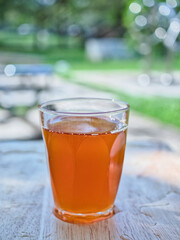 Wild honey in bottles and clear glasses on a wet wooden background
