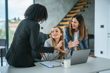 Diverse businesswomen collaborating discussing ideas during office meeting