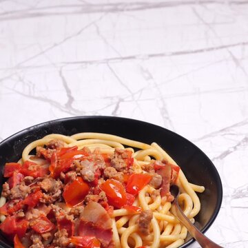 Video quadrato, piatto con pasta condita con salsiccia e pomodorini