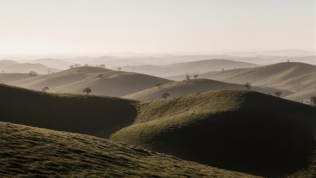 Hazy, rolling green hills dotted with sparse trees in a soft light, evoking a serene atmosphere