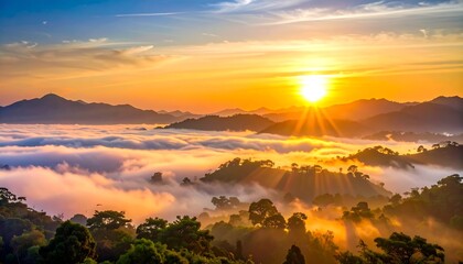 Sunrise bathes a mountainous landscape in golden light, illuminating layers of clouds and forested hills. Sunbeams pierce through the fog