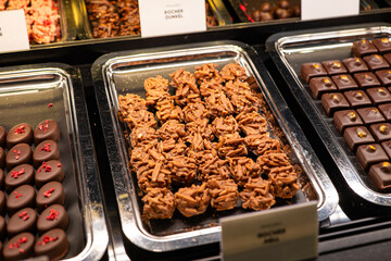 Variety of handcrafted truffles and pralines in a window shop display. Close up, no people