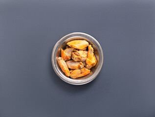 Juicy crispy chicken wings are arranged neatly in a metal bowl against a dark background, showcasing a favorite appetizer ideal for gatherings and casual meals.