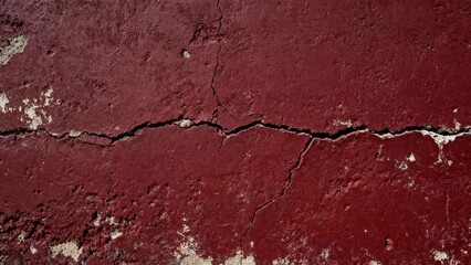 Obraz premium Deep red painted surface displays significant horizontal cracking and surface deterioration