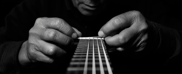 the skilled man deftly replacing a damaged guitar string by hand