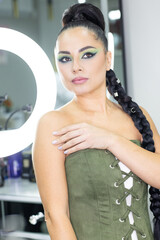 Beautiful European woman getting artistic makeup applied by a professional makeup artist in a modern beauty salon, beauty and elegance concept.