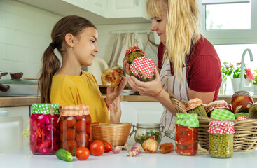 Woman with jar preserved vegetables for winter mother and daughter. Selective focus.