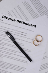 Marital Settlement Separation Divorce Agreement paper document with wedding rings on table, symbolizing divorce, prenuptial contract, prenup, breakup for United Kindom (UK).