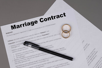 Marriage contract or Marital Settlement Separation Agreement  paper document with wedding rings on table, ready for signature, symbolizing divorce, prenuptial contract, prenup, breakup.