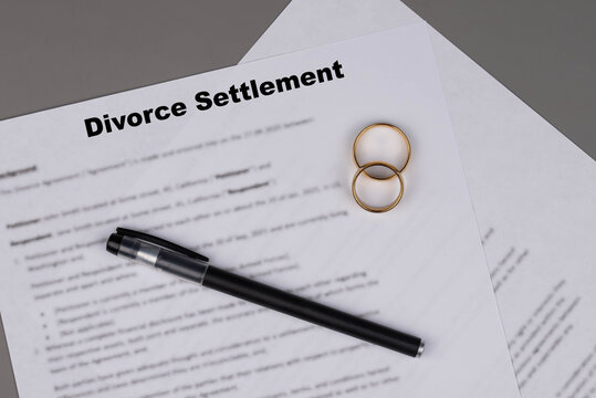 Marital Settlement Separation Divorce Agreement paper document with wedding rings on table, symbolizing divorce, prenuptial contract, prenup, breakup for United Kindom (UK).