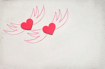 Creative sand texture with two wooden red heart and wings drawing on the sand. Valentine's day and love background. Empty place (pattern) for message. Flat lay. Mockup.
