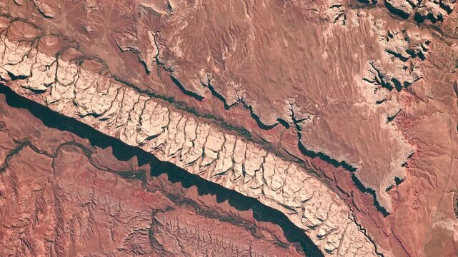 Flying above red rocky desert with prints of erosion in dry area. Wild West concept. Camera is zooming in, rotating counterclockwise. Animation based on image by NASA