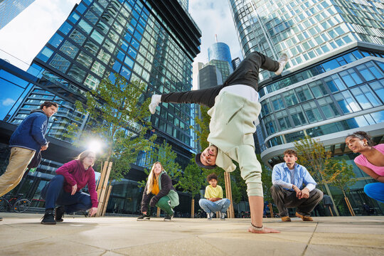 A group of multicultural young people of different ages are breakdancing outdoors. - Powered by Adobe