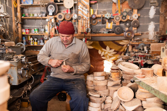 Woodworker Carving Wooden Bowl With Knife In Workshop Crafting Wood Products Woodworking Industry And Carpentr - Powered by Adobe