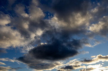 Dark clouds drifting across a blue evening sky
