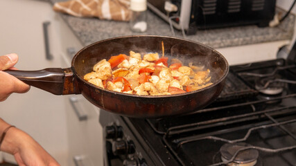 chicken, onion and bell peppers  sauteed in a frying pan