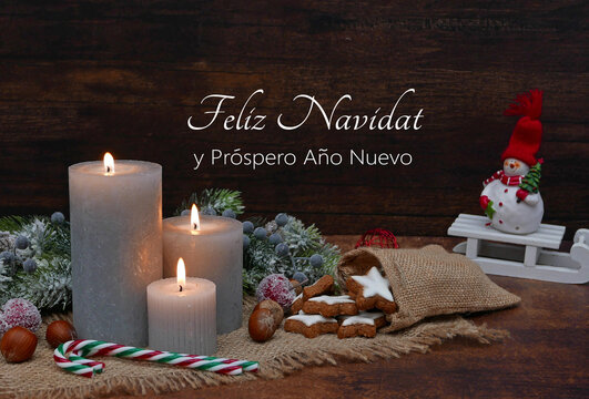 Velas encendidas, adornos navideños, bastones de caramelo, galletas y una figura de Papá Noel se colocan frente a una tabla de madera. ¡Feliz Navidad y próspero Año Nuevo!