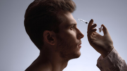 Specialist preparing forehead filler injection to soften expression lines. Concept of clinic promotional visuals, dermatology training, injectables education, and upper-face treatment content.