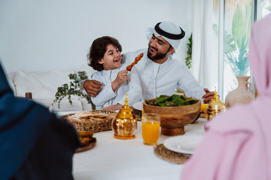 Muslim father son enjoying iftar dinner together