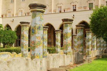 View of the colorful tiled columns of the cloister of Santa Chiara in Naples, Campania, Italy.