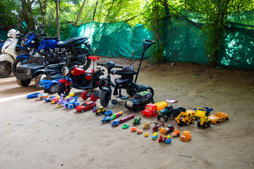 children’s toy assortment featuring cars, trucks in garden area on vishwakarma puja celebration