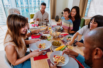 Family and friends reunion at home. Friends and family sharing a meal together at home