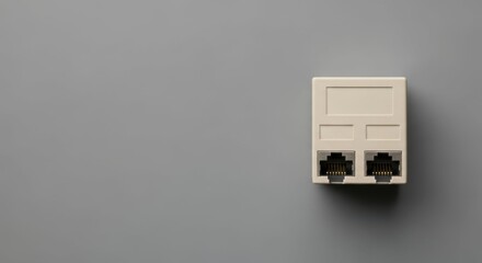 RJ45 connector is shown against gray background. RJ45 connector, used for connecting network cables, is rectangular and off-white. Illustrative RJ45 connector for visual technology communications.