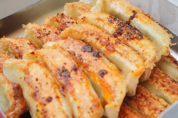 香ばしく焼き目がついた宇都宮餃子を寄りで撮影。カリカリ食感と肉汁を想像させる食欲系写真。飲食店の広告・通販食品紹介・メニュー表にもぴったり