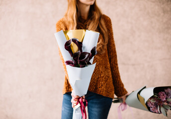 Very nice young woman holding beautiful bouquet of fresh black Cala Lillies, close up cropped view 