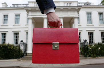 Red UK Budget Briefcase Held by Businessperson