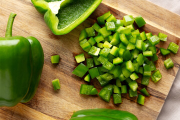 Organic Chopped Green Bell Peppers arranged on a Cutting Board, top view.