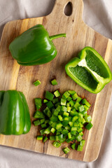 Organic Chopped Green Bell Peppers arranged on a Cutting Board, top view.