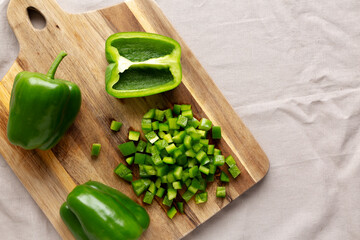 Organic Chopped Green Bell Peppers arranged on a Cutting Board, top view. Copy space.