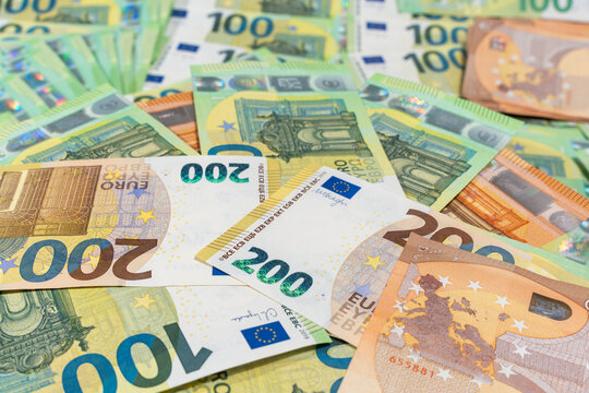 Scattered euro banknotes fill the frame in a bright flat lay. Background image for cash payments, currency, inflation, and European finance.