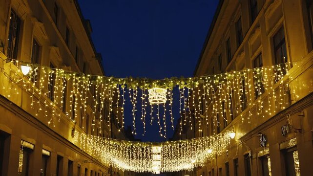 Golden christmas garlands illuminating a european city street for the winter holidays. Festive urban decoration creating a magical atmosphere from dusk until deep night