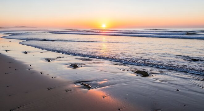 A serene coastal dawn scene. Warm sunlight illuminates the waves, sand, and scattered rocks, creating a peaceful ambiance
