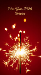 Obraz premium Image of bright sparkler on red backdrop, showcasing New Year 2026 Wishes, symbolizing celebration, joy, and festive cheer, perfect for holiday concepts