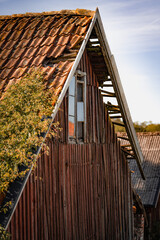 altes leerstehendes Haus mit defektem Dach im morgendlichen Licht