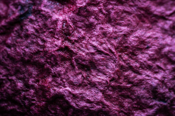 Extreme close up of purple handmade paper clay with a structure and rough texture. Paper recycling. Selective soft focus, shallow depth of field.