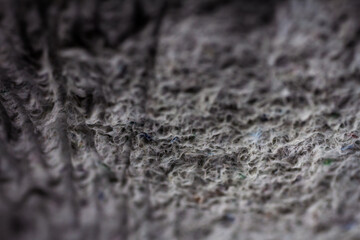 Extreme close up of old gray handmade paper clay with a structure and rough texture. Paper recycling. Selective soft focus, shallow depth of field.