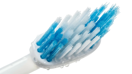 Extreme closeup of a toothbrush head with blue and white bristles against a black background