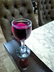 A glass of alcoholic beverage is on the table.