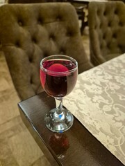 A glass of alcoholic beverage is on the table.