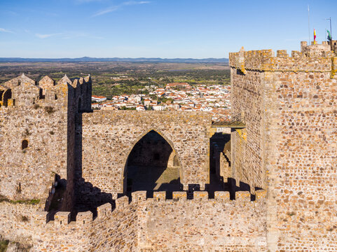 Fortress and Horizon: Imposing connecting arch between towers and crenellated wall of the Castle of Luna in Alburquerque.