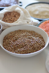 Bowls and bags full of various healthy grains and legumes. Selective focus.