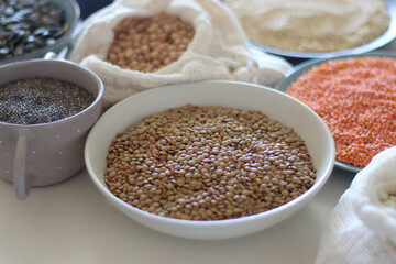 Bowls and bags full of various healthy grains and legumes. Selective focus.